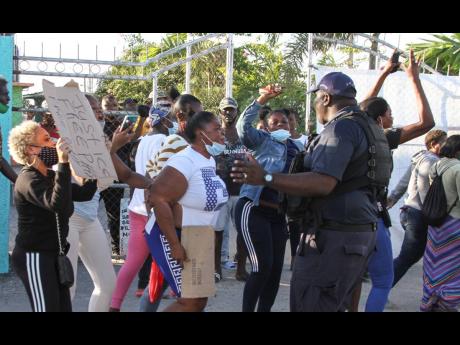 Residents of Rocky Point, Clarendon, protest on Tuesday the detention of Nicholas Graham. The businessman has been in police custody since Sunday afternoon.