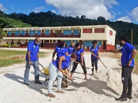 Members of the Kiwanis Club of Charlton-Alexandria spreading marl on the driveway at the Aboukir Primary School before it was paved.  