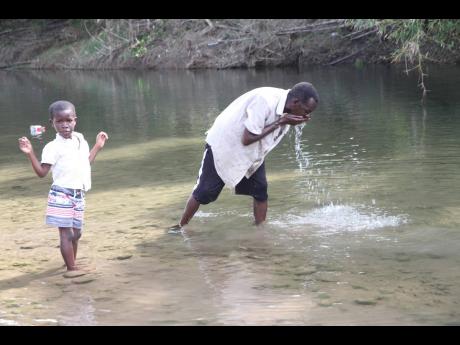 Sixty five-year-old Earlston Seaton and his five-year-old grandson, Jacquan, at the Rio Minho.