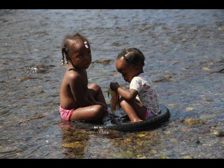Two children play in the Rio Minho in Clarendon.