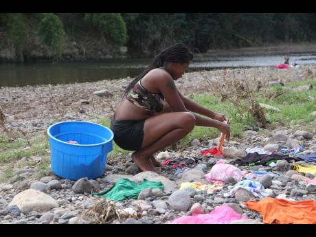 Crystal Christian is seen washing in the Rio Minho and placing her clothes on stones to dry.