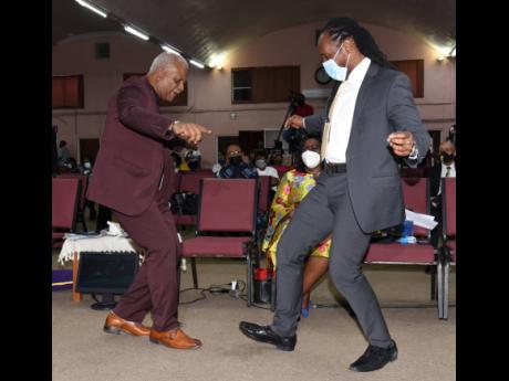 The Reverend Merrick 'Al' Miller (left), pastor of Fellowship Tabernacle, and Alando Terrelonge, state minister in the Ministry of Culture, Gender, Entertainment and Sport, shows off their dance moves during the Reggae Month church service held at Fellowsh