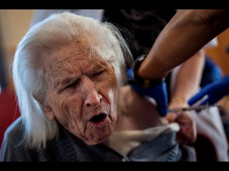 A nurse administers the Pfizer-BioNTech COVID-19 vaccine to a resident at the Icaria nursing home in Barcelona, Spain, on Tuesday. Spain's top coronavirus expert suggests that the coronavirus vaccine manufactured by AstraZeneca should be administered to yo