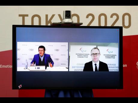 Christophe Dubi, Olympic Games Executive Director for the International Olympic Committee (IOC), left, and Craig Spence, Chief Brand and Communications Officer for the International Paralympic Committee (IPC), join other representatives from the Tokyo Orga