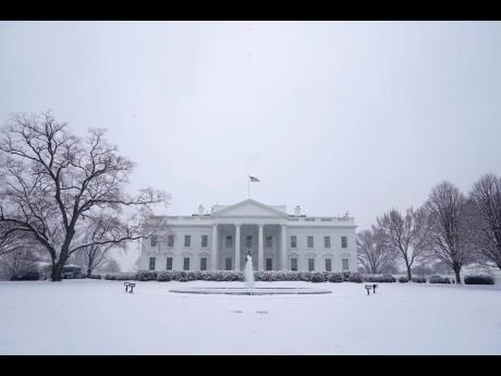 
Snow falls on the North Lawn of the White House on Sunday, January 31, in Washington. 