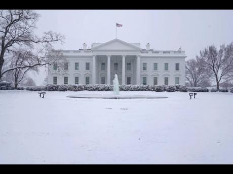 Snow falls on the North Lawn of the White House on Sunday, January 31, in Washington.