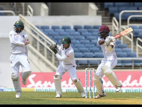 Windies batsman Kraigg Brathwaite (right) cuts a shot as Bangladesh’s Liton Das (left) and Nurul Hasan look on during a Test match at Sabina Park on Thursday, July 12, 2018.