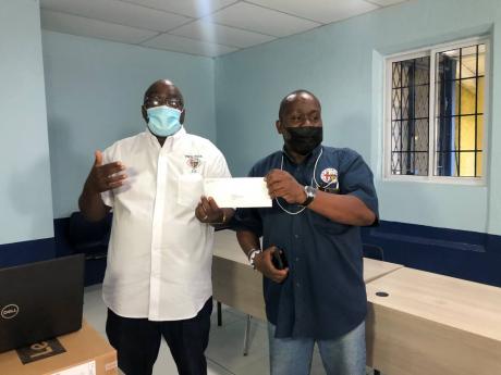 Acting Principal Wayne Robinson (left), accepts a cheque from Noel Brown on behalf of the Jamaica College Old Boys Association.