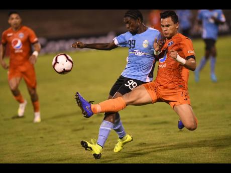Denil Maldonado from Honduran club FC Motagua gets a toe to the ball ahead of Waterhouse’s Colorado Murray during their Concacaf League match at the National Stadium.