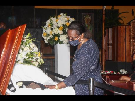 Joy Smith saying goodbye to her late husband, transport icon Ralph Smith, as she viewed his body at the Blessed Sacrament Cathedral in Montego Bay, St James in Wednesday.