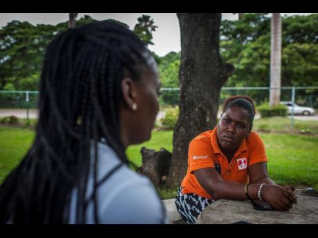 
Eve for Life mentor Monique McDonald (right) speaks with Shelly (left, back to the camera) at a public park in Ocho Rios, St Ann.