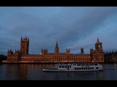 The Palace of Westminster viewed from the south side of the embankment by the River Thames just after dawn in London, on January 18, 2021.