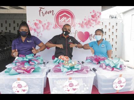Clover Moore (left), assistant vice-president, group corporate affairs and communication, Victoria Mutual Group; Courtney Campbell, group president and CEO; and Hotiyana Brown, secretary to the Inspector of Poor, greet each other during the handover of the