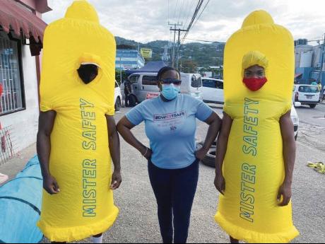 Members of the Jamaica AIDS Support for Life (JASL) team pose with two females at Strand Street in downtown Montego Bay after issuing condoms and lubricants. JASL has launched an HIV prevention campaign dubbed ‘DWEET SAFE’, which is geared towards enco