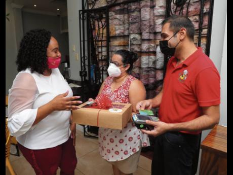 Monica Khemlani (centre), who opted to have her special Valentine’s Day dinner at home, engages in conversation with Sagicor Bank’s Nicola Speid (left) and Rajiv Harpalani, co-owner, Julie Mango restaurant.