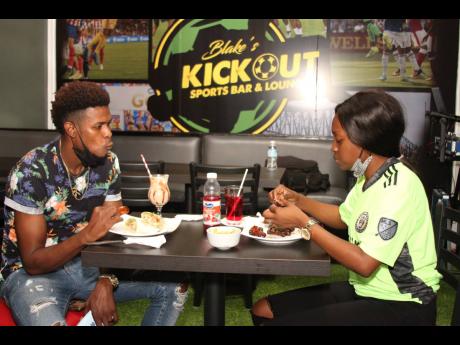 Owners of Blake’s Kickout Sports Bar and Lounge Andre Blake and his wife Shauna-Kay enjoy a meal at their newly-opened establishment.