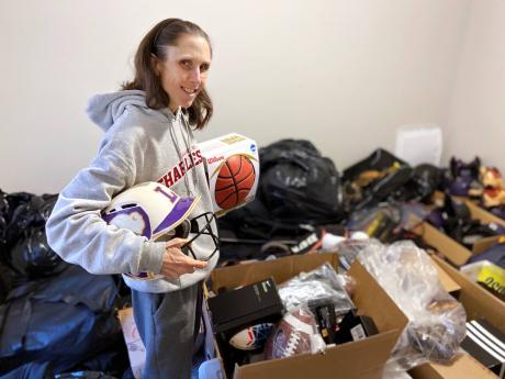 Rhiannon Potkey displays the sports equipment collected by Goods4Greatness, the non-profit she started to get much-needed gear to low-income children and teens. 