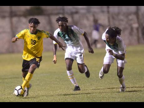 Jamaica’s Tyreek Magee (left) dribbles under pressure from Dominican defenders George Usher (centre) and Jolly Fitz during their Concacaf Olympic Qualifier at the Anthony Spaulding Sports Complex in Kingston, Jamaica, on Wednesday, July 17, 2019.