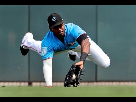 Miami Marlins centre fielder Lewis Brinson dives to catch a fly ball by Washington Nationals’ Adam Eaton for an out during the third inning of an exhibition spring training baseball game in Jupiter, Florida on March 1, 2019. 