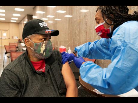 Reginald Henry, 69, of Washington, receives his second dose of the COVID-19 vaccine at a clinic at Howard University, in Washington. “I felt confident about getting the vaccine,” says Henry, who lives in a senior citzens’ building, “because God hel