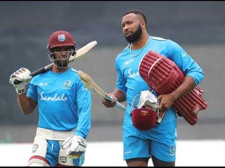 West Indies’ white-ball captain Kieron Pollard (right) and Nicholas Pooran walk to bat in the nets during a training session ahead of their first One-Day International cricket match against India in Chennai, India, in December 2019.