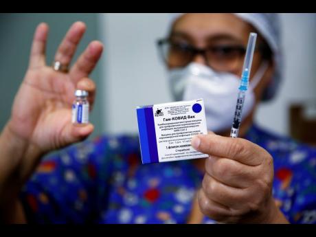 A nurse holds up the Sputnik V vaccine for COVID-19 at the National Hospital as vaccinations start in Itaugua, Paraguay. 