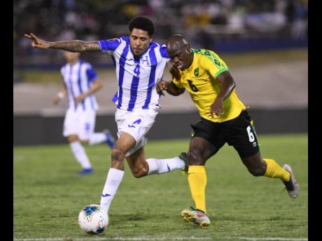 Jamaica’s Dever Orgill (right) moves away from Honduran player Henry Figueroa in their Concacaf Gold Cup match held at the National Stadium on June 18, 2019. 
