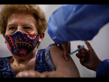 Beatriz de Gregorio gets a shot of the AstraZeneca vaccine for COVID-19 in Buenos Aires, Argentina, on Monday as the capital begins to inoculate people over the age of 80 for the new coronavirus. 
