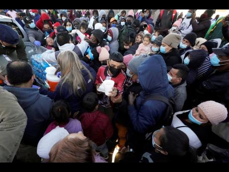 Asylum seekers receive food as they wait for news at the border on February 19 in Tijuana, Mexico. 