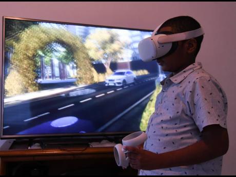 Dominic Darby, 11, immerses himself in a virtual world with his Oculus Quest 2 at his Portmore, St Catherine, home on Tuesday. The Wolmer’s Prep student and coder emerged winner in the Junior division of the XPRIZE Code Games Challenge.