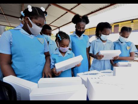 Students of Gregory Park Primary School examine some of the 26 tablets donated to the school by the Kiwanis Club of South St Catherine.