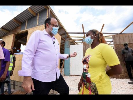 Mark Golding, Opposition leader and president of the People’s National Party, listens keenly to Shian Ganpatt, former occupier of lands at Innswood Estate in St Catherine.  Ganpatt was evicted and her home destroyed recently.