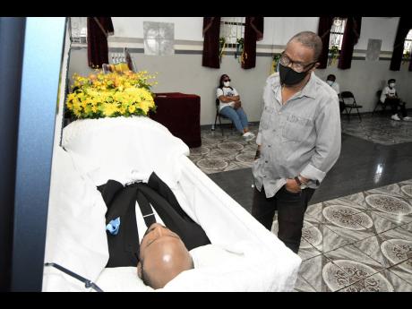 Clyde Jureidini, general manager of Harbour View Football Club, views the body of former national footballer Luton Shelton at the House of Tranquillity Funeral Home on Orange Street in Kingston on Wednesday, February 24, 2021.