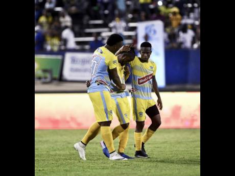 Waterhouse FC players Shawn Lawes (left) and Cardel Benbow (right) console teammate Kemar Beckford after his penalty shootout miss against Portmore United in the Jamaica Premier League final at the National Stadium on April 23, 2018.