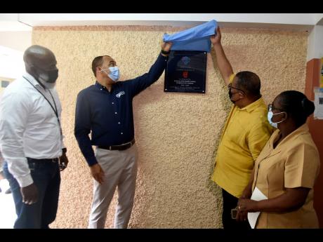 Hardware & Lumber Managing Director Marcus Richards (left) and Nurse Winnifred Reid-Foster (right) look on as Health and Wellness Minister Dr Christopher Tufton (second left) and St Andrew Western Member of Parliament Anthony Hylton unveil a plaque marking