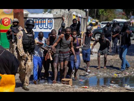 Recaptured inmates are led by police outside the Croix-des-Bouquets Civil Prison after an attempted breakout in Port-au-Prince, Haiti, on Thursday.