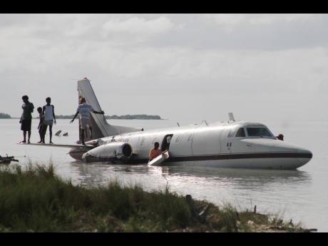 Residents of Rocky Point scavenge for souvenirs from the crash-landed plane. 