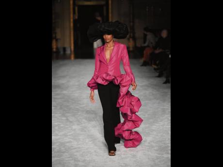 A model walks the runway at the Christian Siriano Fall-Winter 2021 at Gotham Hall during New York Fashion Week in a plunging, voluminous, fuchsia jacket. 