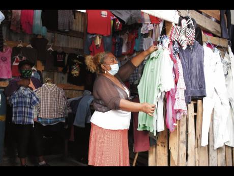  Rosemarie Maragh tends to some of the items she has on sale while one of her employees look on.