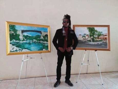 Artist Delroy Millwood with paintings of the Spanish Town Bridge (left) and Spanish Town Square.