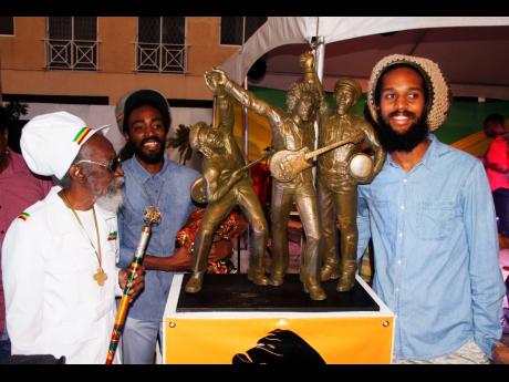 Bunny Wailer (left) his son, Abijah ‘Asadenaki’ Livingston (second left), and Andre ‘Dre’ McIntosh, the grandson of Peter Tosh, pose with the maquette for the statue of The Wailers. 