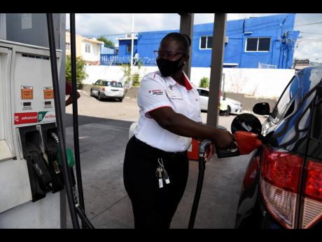A pump attendant watches the reading at the Total service station on Shortwood Road, St Andrew, on February 8. Jamaica Gasolene Retailers Association President Dianne Parram says she does not forsee a significant shift from petrol- to electric-powered vehi
