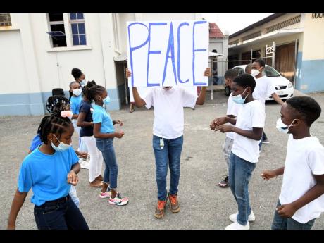 Members of the St Matthew’s Optimist Club participate in a Peace Day activity on Tuesday. 