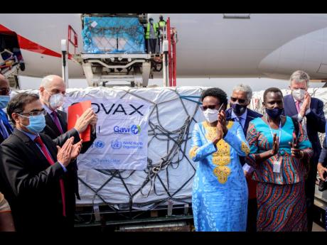 Uganda’s Minister of Health Dr. Jane Ruth Aceng, center right, and other officials greet the country’s first consignment of AstraZeneca COVID-19 vaccine manufactured by the Serum Institute of India and provided through the global COVAX initiative, at t
