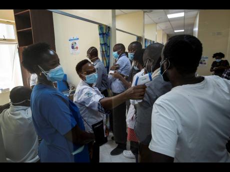 Medical staff wait in line to receive some of the country's first coronavirus vaccinations using AstraZeneca COVID-19 vaccine manufactured by the Serum Institute of India and provided through the global COVAX initiative, at Kenyatta National Hospital in Na