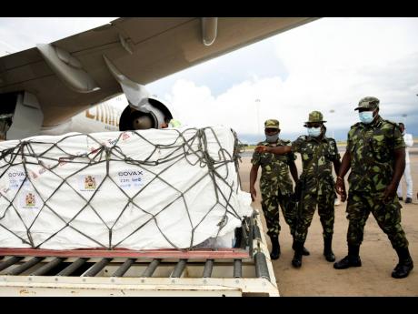 Malawian police guard AstraZeneca COVID-19 vaccines after the shipment arrived at the Kamuzu International Airport in Lilongwe, Malawi, Friday March 5, 2021. The country is the latest in Africa to receive vaccines in a fight against COVID-19. (AP Photo/Tho