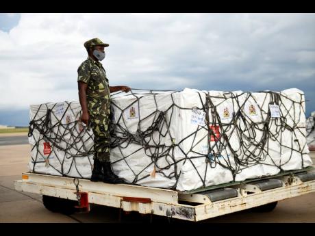 A Malawian policeman guards AstraZeneca COVID-19 vaccines after the shipment arrived at the Kamuzu International Airport in Lilongwe, Malawi, Friday March 5, 2021. The country is the latest in Africa to receive vaccines in a fight against COVID-19. (AP Pho