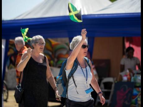 
Jacqui Phillips (left) and Debbie Towersey both from Gloucestershire, England, wave Jamaicans flags as they walk to Fort Charles after visiting Jamaica for the first time in February 2020.