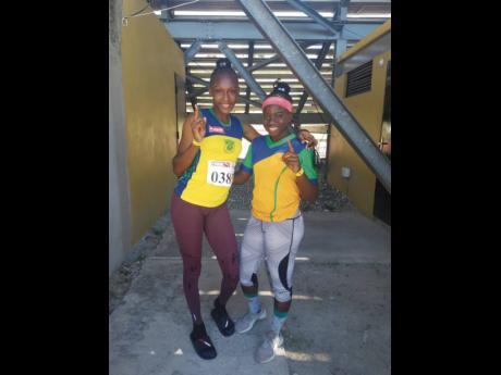 Rusea’s High School sprinters Aalliyah Francis (left) and Lavanya Williams pose together at Stadium East after competing at the Jamaica Athletics Administrative Association Qualifying meet at the National Stadium yesterday. 
