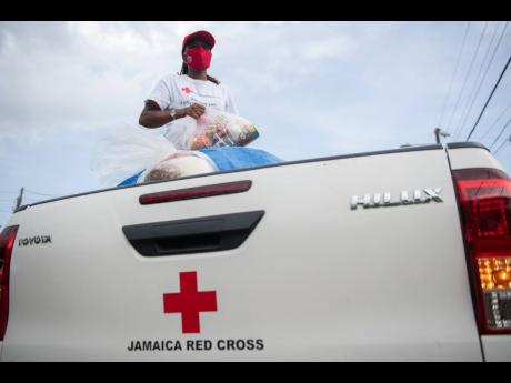 A welfare worker prepares to distribute supplies to residents of Sandy Bay, Clarendon, on August 6, 2020, during a 14-day coronavirus lockdown.
